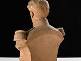 a clay bust of a man with a cup in his hand