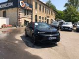 a black car parked in front of a building in a parking lot