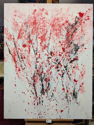 une peinture abstraite posée sur un chevalet, maculée d'éclaboussures de peinture rouge et noire