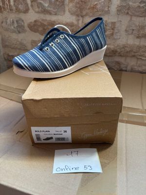 blue and white striped shoes on top of a box on a table