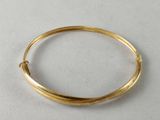 a close up of a gold bracelet on a white surface