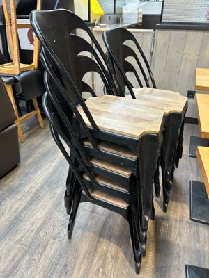 six chaises noires alignées dans un restaurant