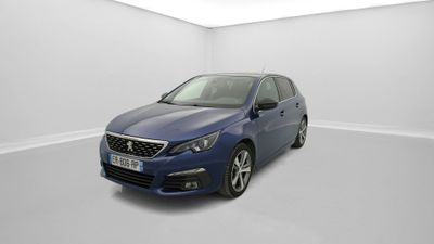 Une voiture bleue est garée dans une pièce blanche au sol blanc.