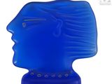 une sculpture en verre bleu représentant une tête d'homme sur fond blanc