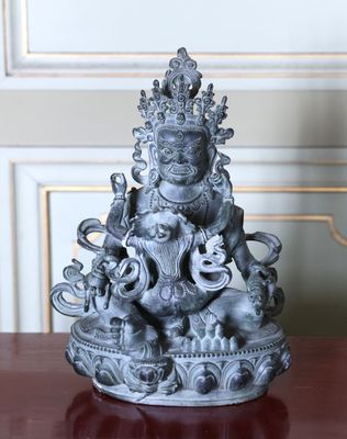 une statue d'un homme assis sur une table