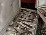 silverware in a case sitting on a table with other silverware in it