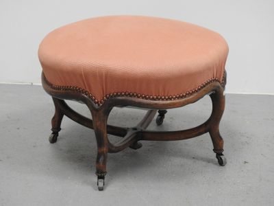 une image représentant un petit tabouret sur lequel est posé un coussin rose