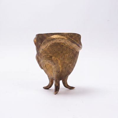 un petit vase en bronze sur lequel est représenté un oiseau debout