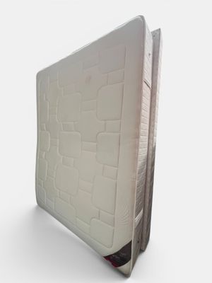 une photo d'un matelas posé sur une surface blanche