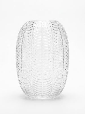 un vase en verre posé sur une surface blanche