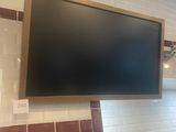 une télévision à écran plat fixée au mur au-dessus d'un lavabo