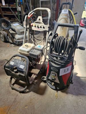 deux nettoyeurs haute pression dans un garage où des outils traînent par terre