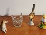 three figurines of cats and a bird sitting on a table