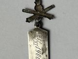 a small silver medal with a cross on top of it