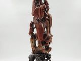 a statue of a woman sitting on top of a rock