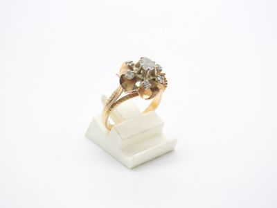 gros plan d'une bague en or avec des diamants sur une surface blanche