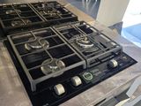 a black stove top with four burners on it