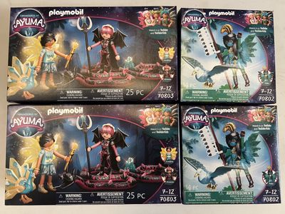 four playmobil figures are shown on a table in front of a white background