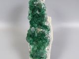 a close up of a piece of green crystals on a white surface
