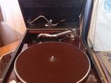 un vieux tourne-disque posé dans une valise sur une table