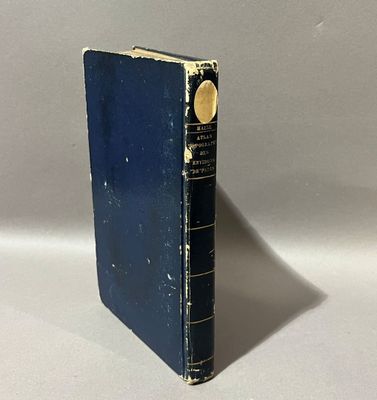 un livre bleu posé sur une table à côté d'un mur blanc