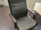 a black office chair sitting in front of a computer desk
