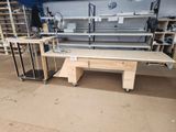 a workbench in the middle of a room with a lot of shelves