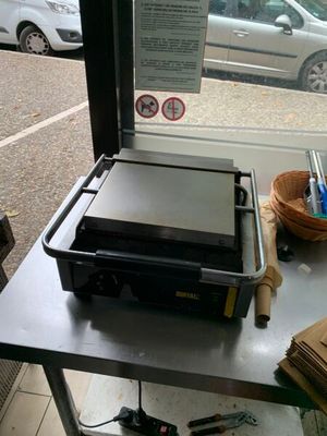 une photo d'un four à pizza posé sur une table devant une fenêtre