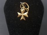 an image of a gold cross charm on a black display case