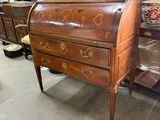 a wooden desk with drawers and a chair in the background