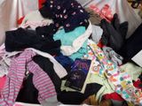 a pile of clothes in a suitcase on a bed