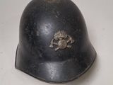 an old helmet is sitting on a table with a white background