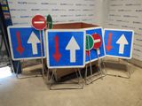 four signs with arrows on them in a room