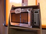 a microwave on a shelf with a price tag on it