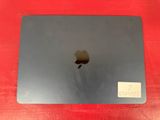 a close up of an apple laptop on a red surface