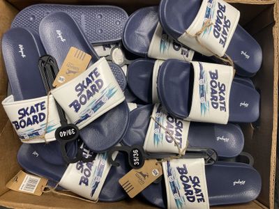 de nombreuses paires de tongs bleues dans une boîte en carton