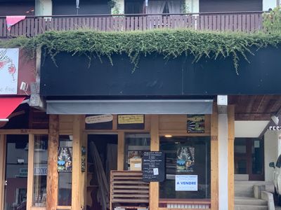 a car parked outside of a restaurant with plants growing on the roof