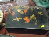 une boîte noire décorée de fleurs, posée sur une table