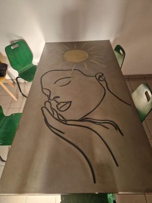 une table sur laquelle est posé un dessin, au milieu d'une pièce