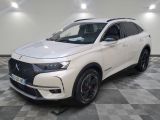 un SUV DSX blanc garé dans un showroom au sol carrelé