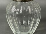 an image of a glass jar with a silver lid on a gray surface