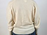 the back view of a woman in a white sweater and jeans