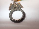 a silver ring with an eagle on it on a table