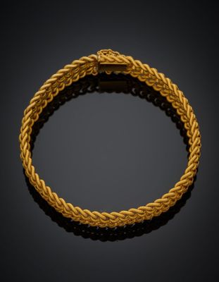 un bracelet en or avec un motif tressé sur fond noir