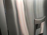 a person holding a stainless steel refrigerator in their hand