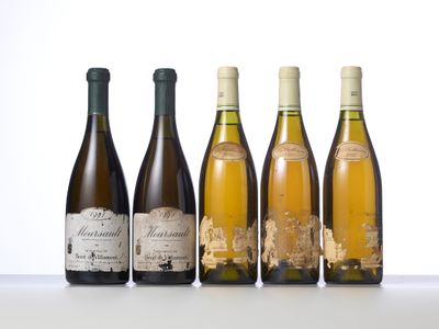 four bottles of wine are lined up on a table