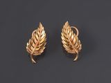 a pair of gold earrings on a black background