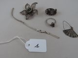 a lot of silver jewelry on a table with a price tag