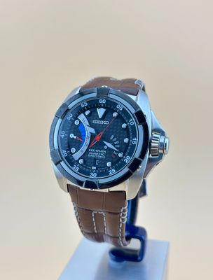 la montre est posée sur un socle, sur une surface blanche