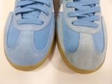 blue and white tennis shoes on a white surface with a white background